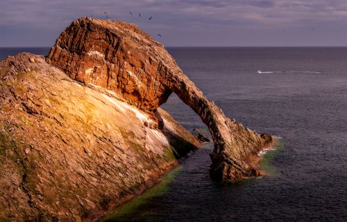 Free Scenic view of Bow Fiddle Rock, a striking sea arch formation in Portknockie, Scotland. Stock Photo