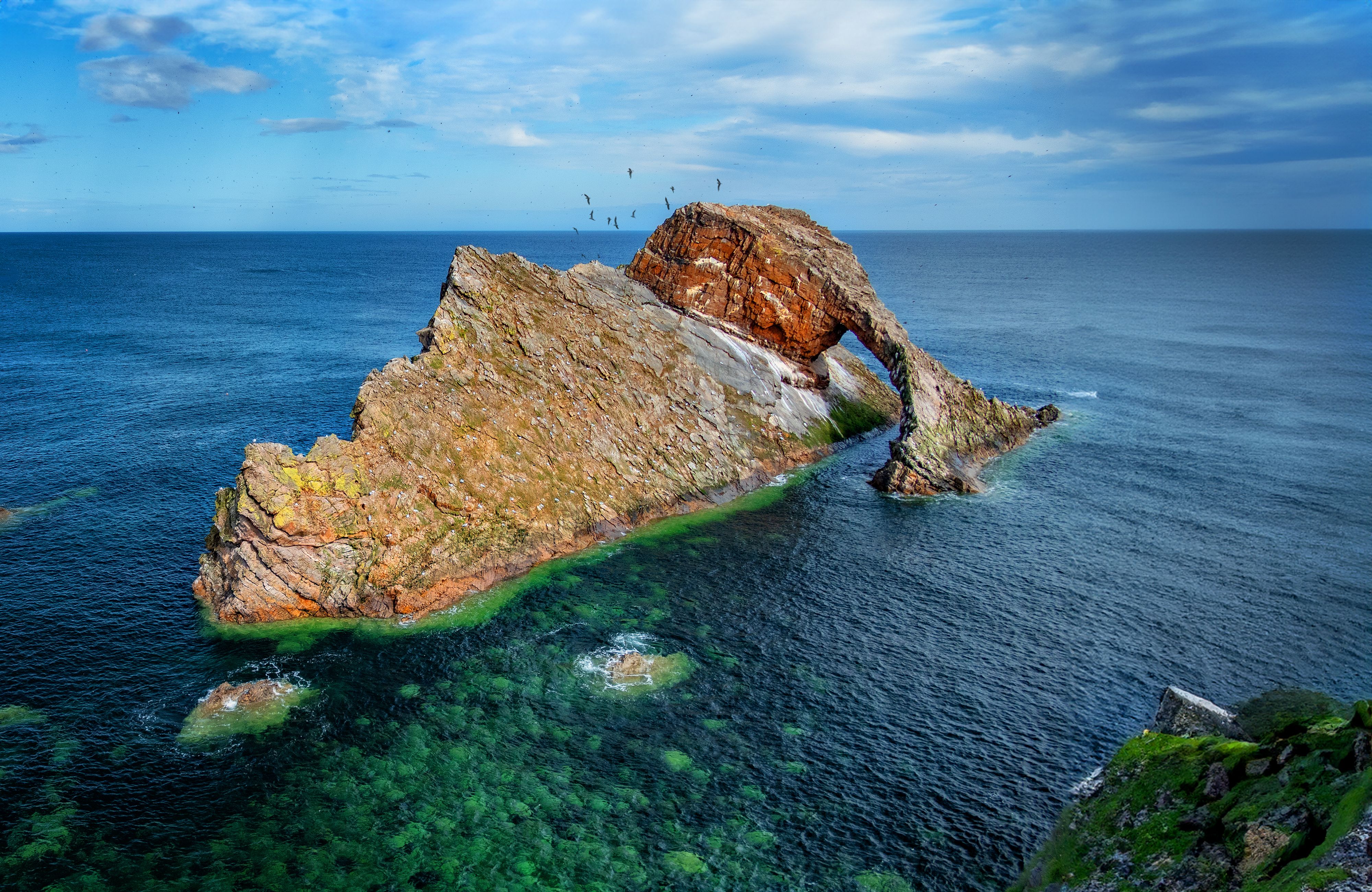 Beautiful view of Bow Fiddle Rock, a striking sea arch rock formation in Portknockie, Scotland.