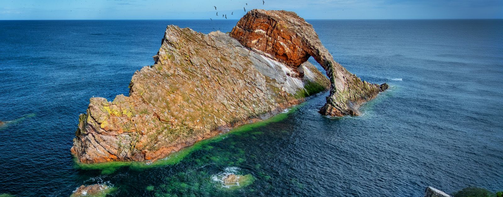 Beautiful view of Bow Fiddle Rock, a striking sea arch rock formation in Portknockie, Scotland.
