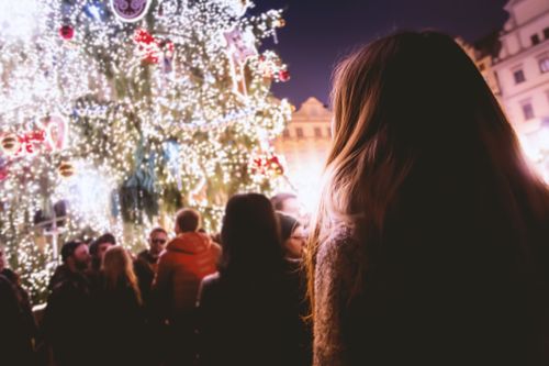 Free People enjoying a festive Christmas celebration with illuminated trees and joyful atmosphere at night. Stock Photo