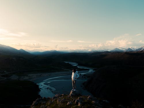 Photo of Man Standing on Rock Near Cliff Edge