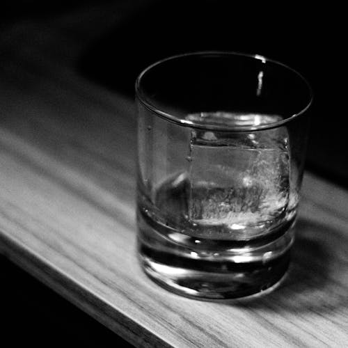 A glass of whiskey sits on a table