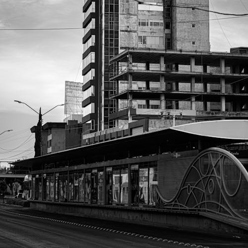 A black and white photo of a train on a street