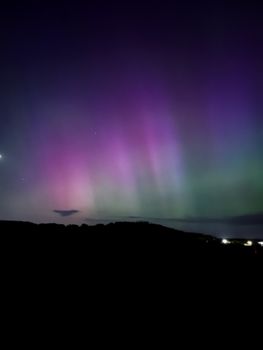 Magnificent aurora borealis with vibrant purple and green hues illuminating the night sky.