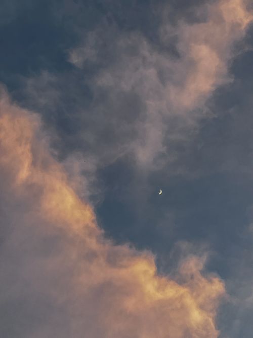 Free Serene sky with colorful clouds and a crescent moon at dusk. Stock Photo