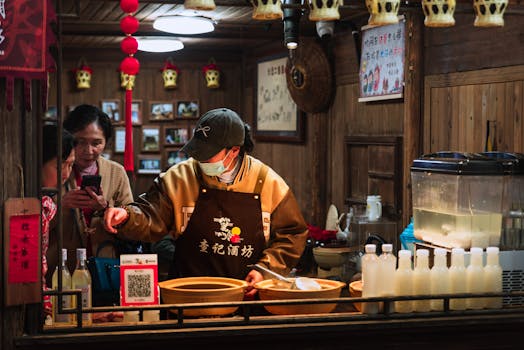 A traditional Chinese food stall indoors with staff preparing and serving drinks.