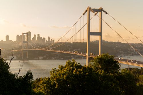 Free Scenic view of the Bosphorus Bridge at sunset in Istanbul, with the city skyline as a backdrop. Stock Photo