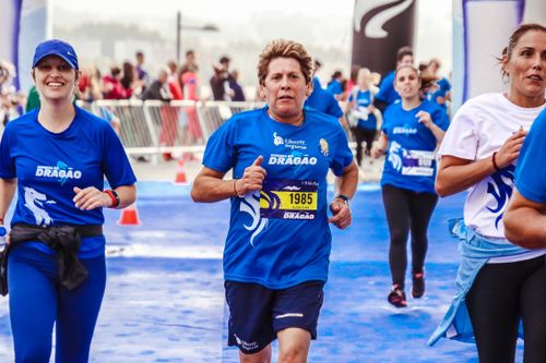 Free Energetic participants running in a marathon event with a bright blue theme. Stock Photo