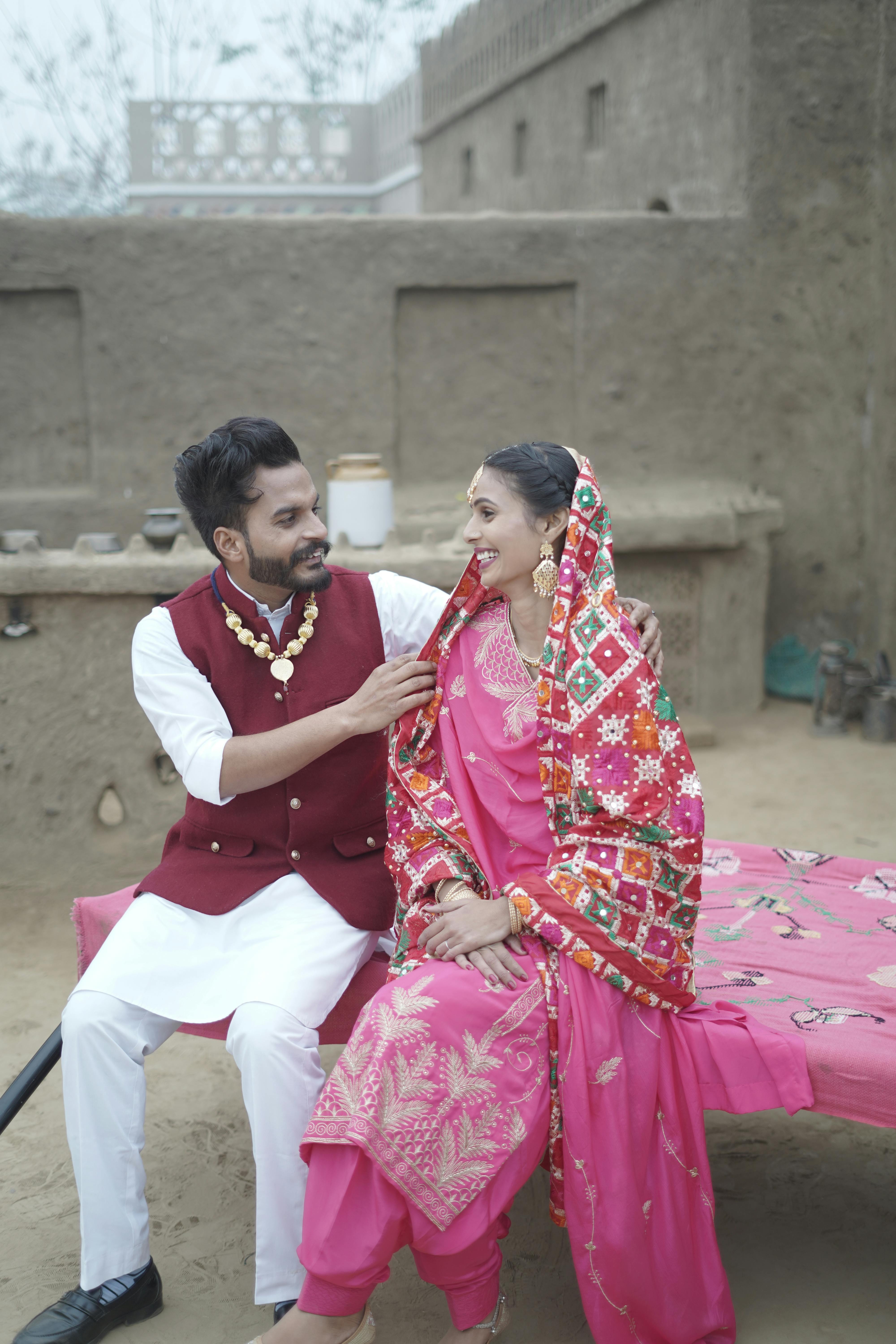 A couple in traditional Punjabi clothing sharing a moment in rural Amritsar, India.
