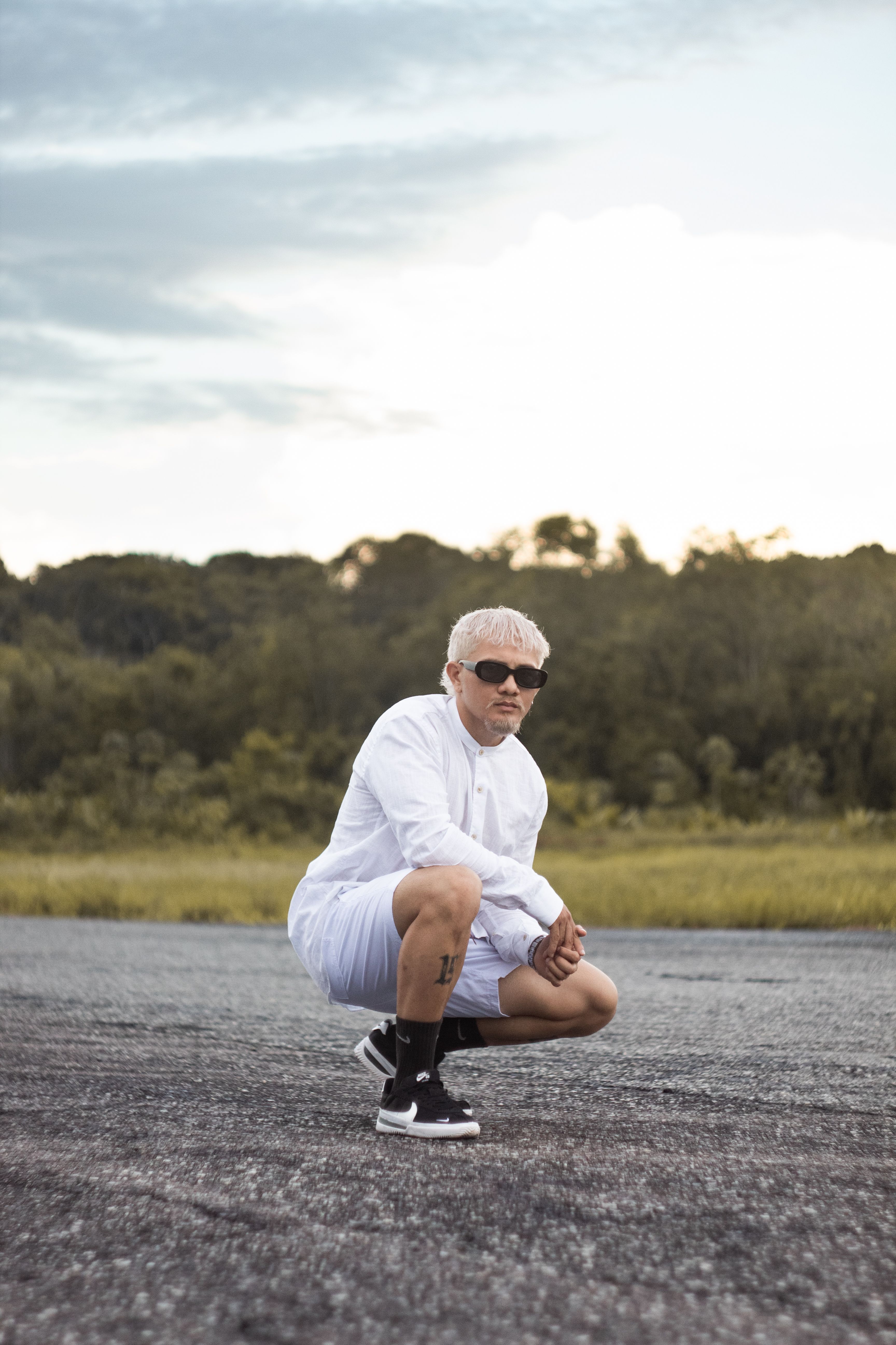 A Man Squatting on the Road · Free Stock Photo