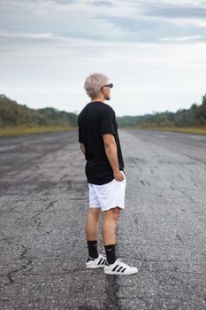 Blonde man with sunglasses standing on a rural road in Breves, Brazil.