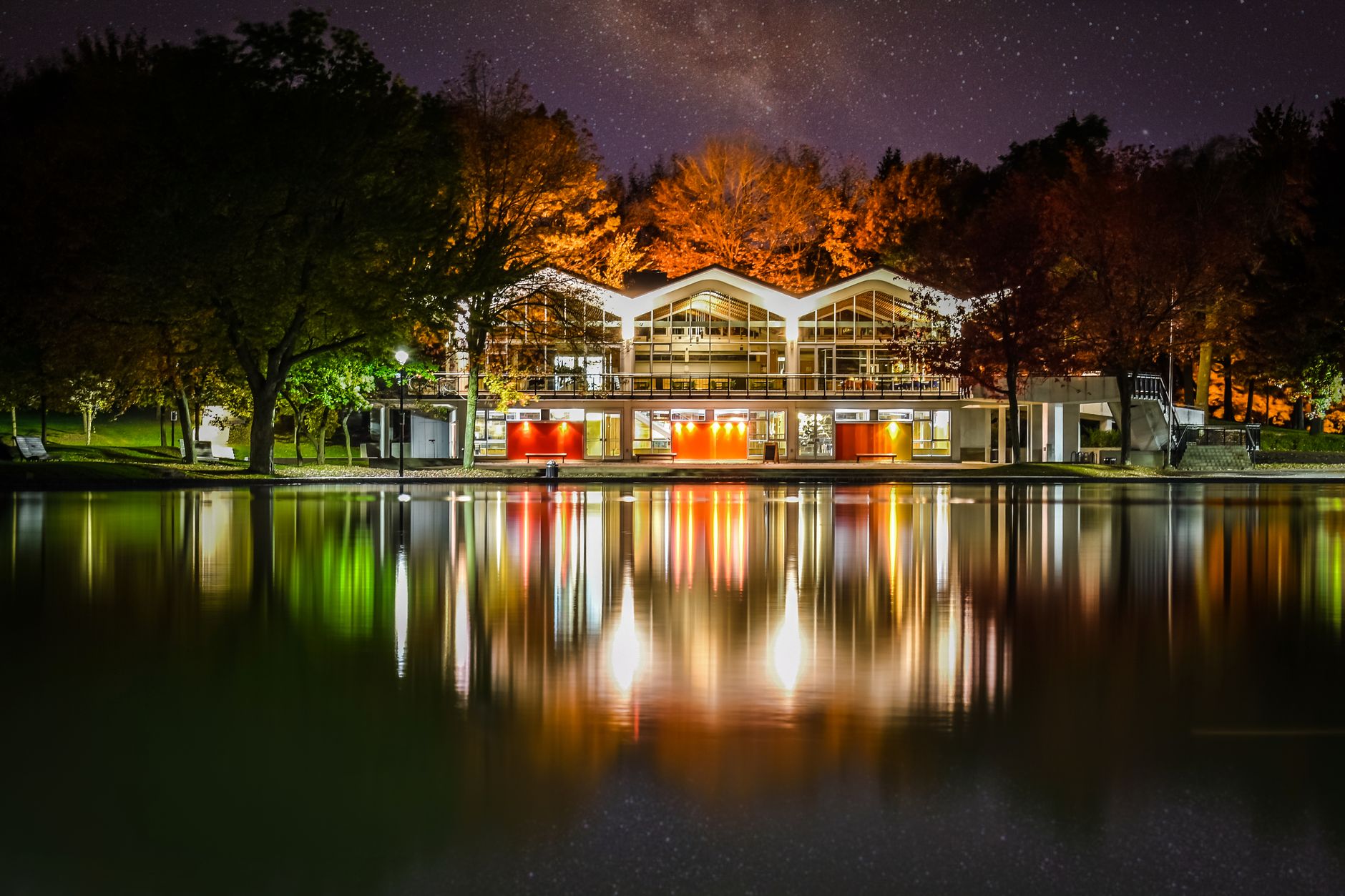 Serene night view of Pavillon Du Lac-Aux-Castors reflecting in a pond in Montreal's autumn park.