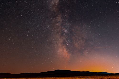 Free A breathtaking view of the Milky Way galaxy above a serene Romanian landscape during the night. Stock Photo