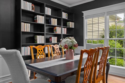 A dining room with a black bookcase and a table