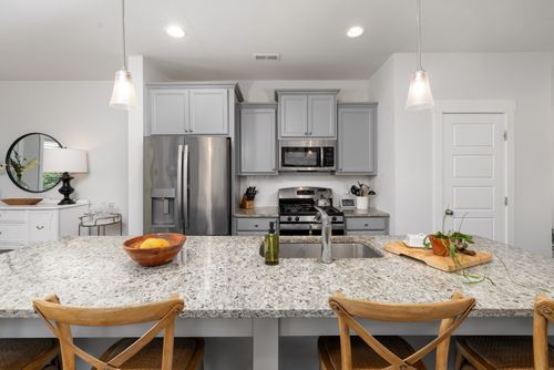 Free Sleek kitchen design featuring granite countertops, stainless steel appliances, and contemporary chairs. Stock Photo