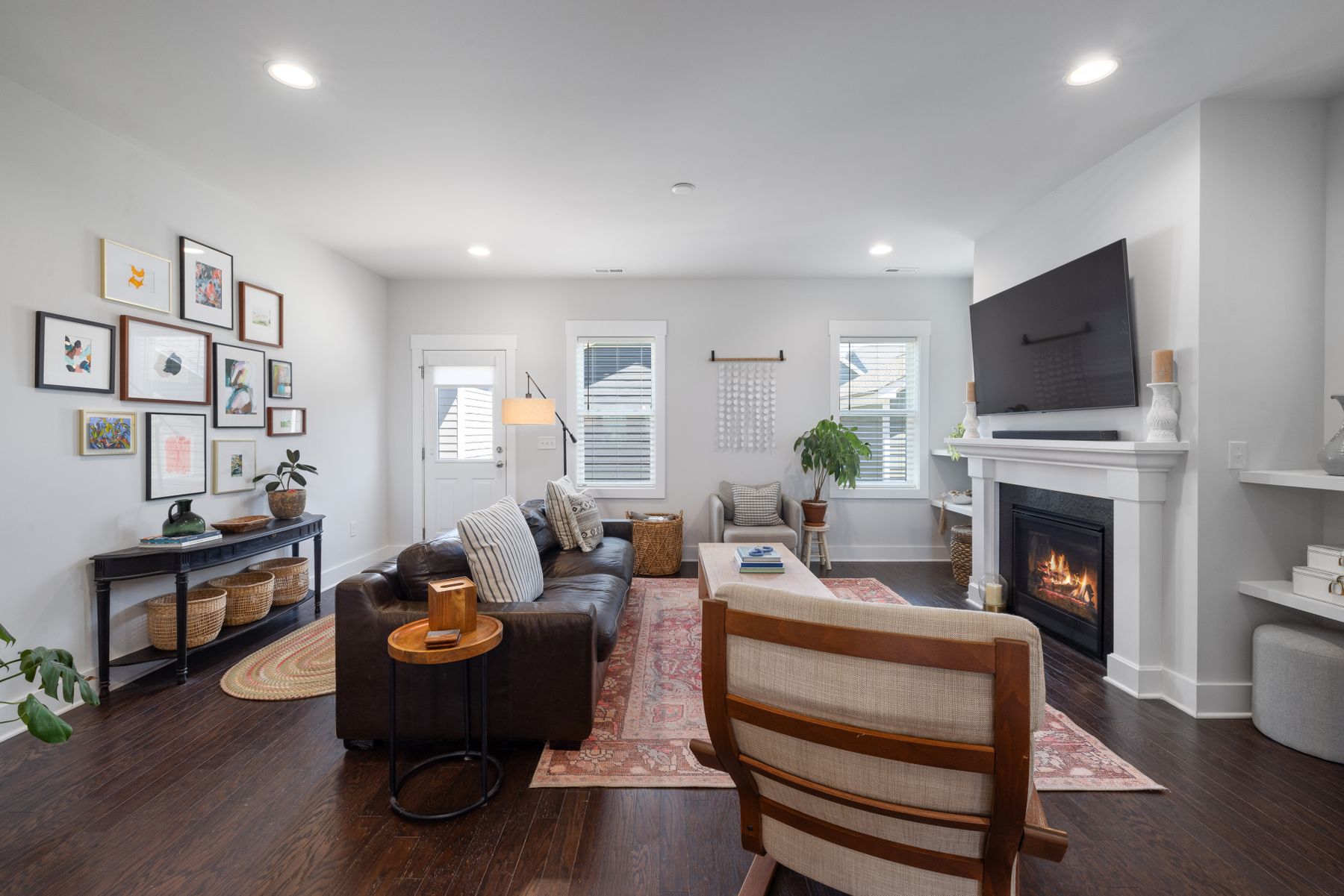 Modern living room with sofa, armchair, rug and fireplace