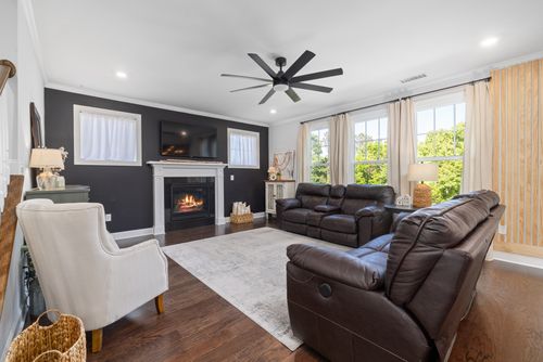 Free Spacious modern living room featuring leather sofas, a fireplace, and a large TV. Stock Photo