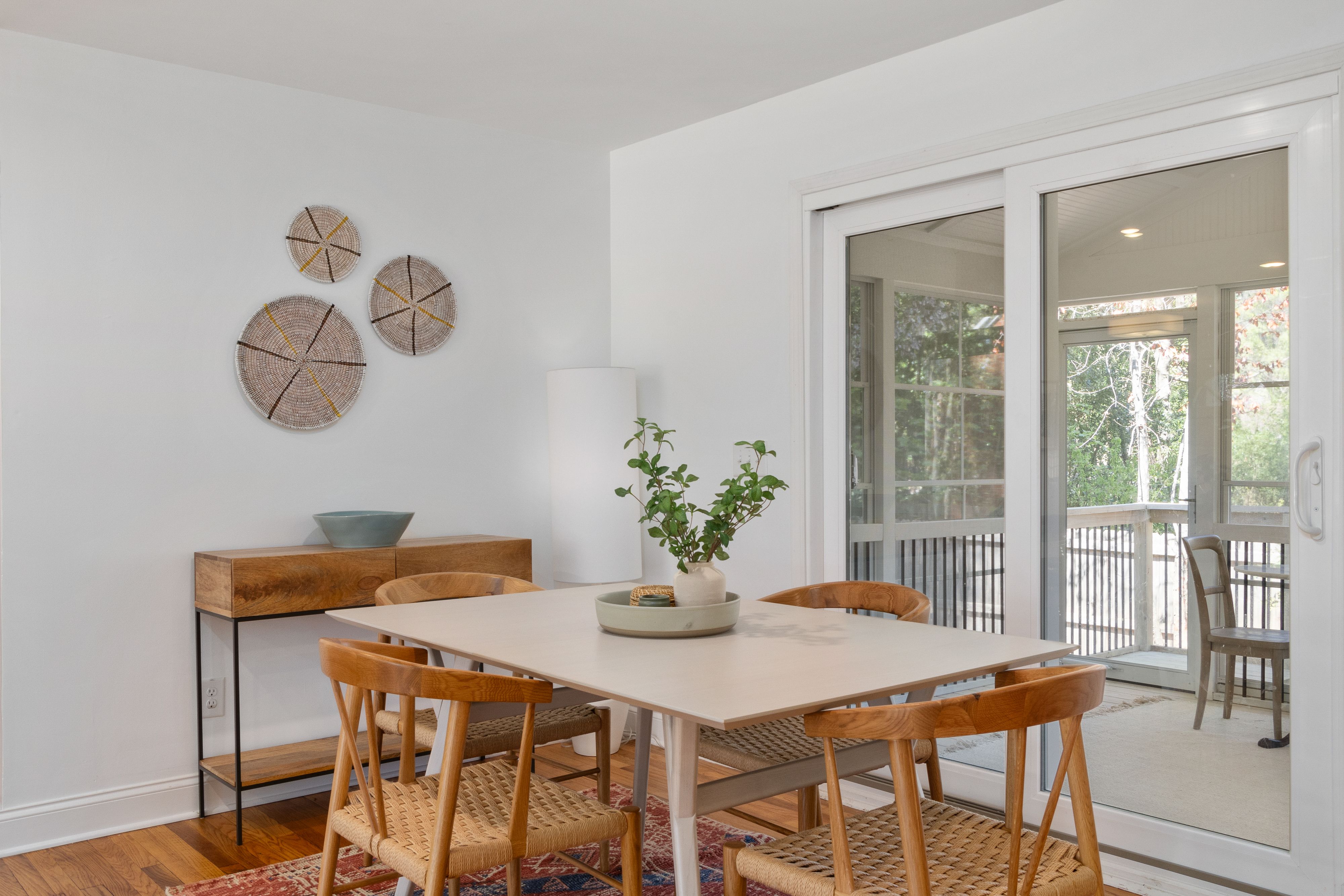 natural wood and woven end chairs in a bright dining room