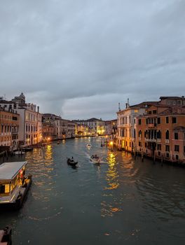 Scenic view of Venice's Canal Grande with gondolas under a twilight sky, capturing the city's charm.