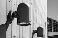 Black and white photo of two street lights on a wall