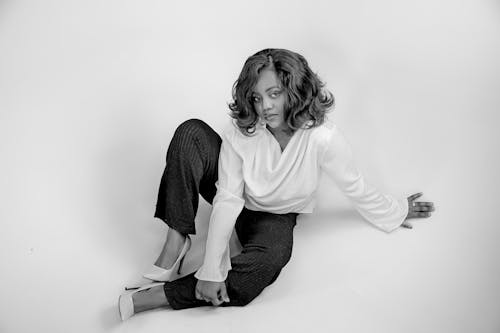 A woman sitting on the floor in a black and white photo