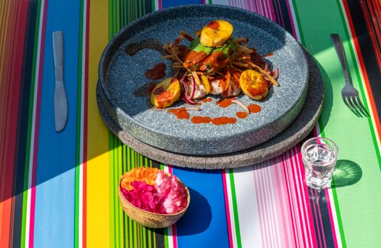 Colorful Mexican meal setting with vibrant tablecloth and dish in Mexico City.