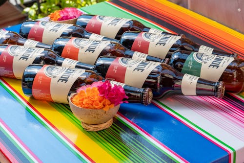 A colorful table with bottles of beer and flowers