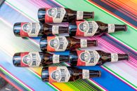 Vibrant display of Allende beer bottles on Mexican textile in CDMX.