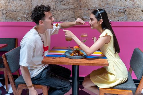 Free A young couple enjoying a meal at a colorful cafe in CDMX, showcasing vibrant Mexican interiors. Stock Photo