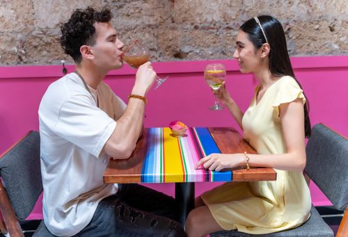Free A young couple enjoying beverages together at a colorful restaurant in CDMX, Mexico. Stock Photo