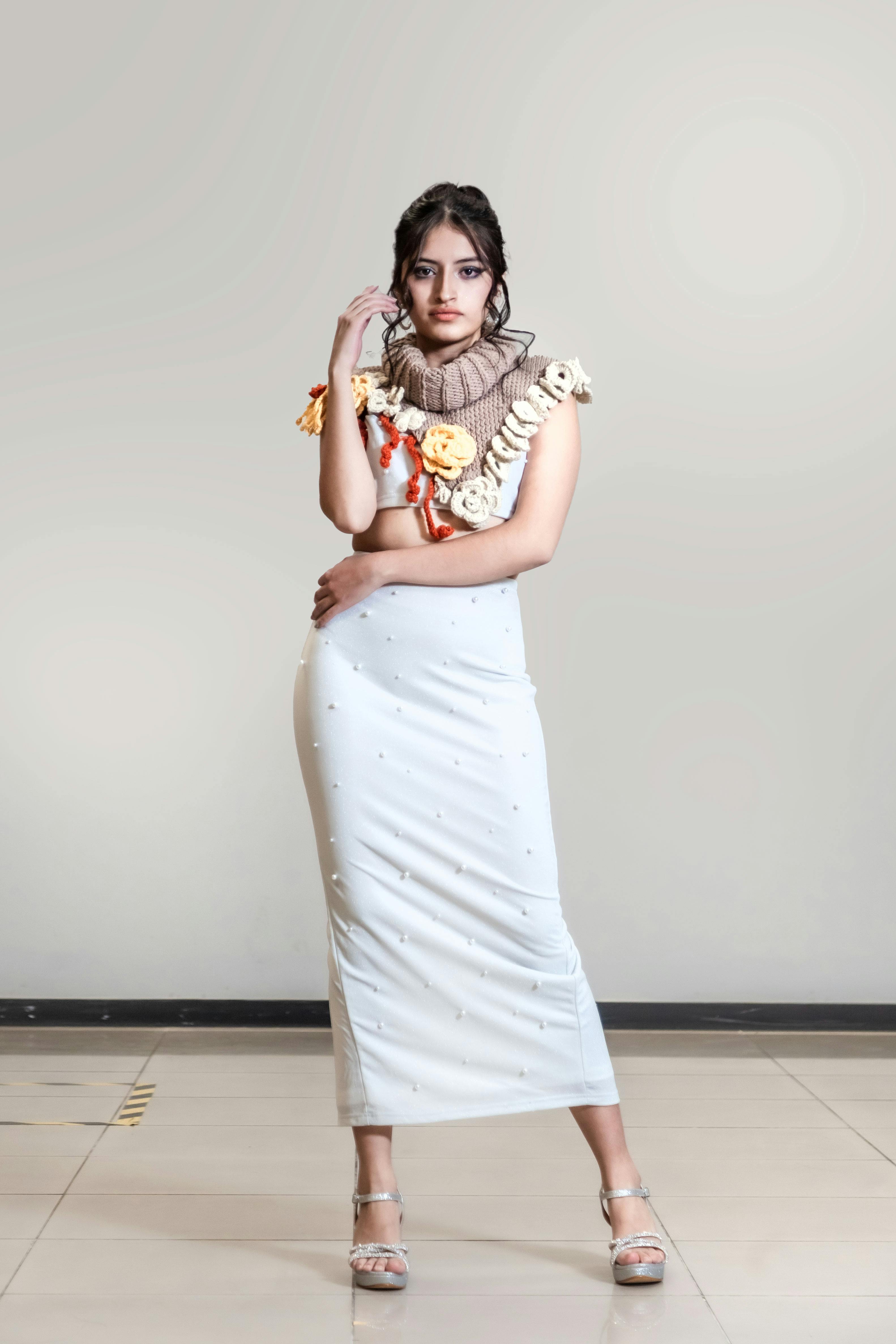 Free Fashion model posing indoors in a designer dress, showcasing modern elegance. Stock Photo