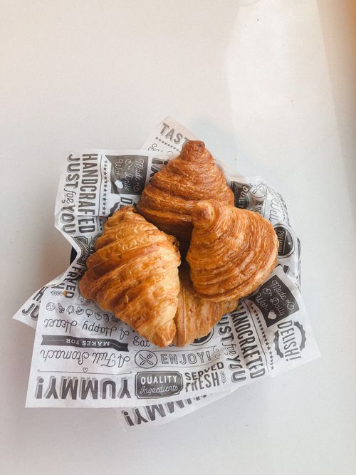 Free Golden croissants on decorative paper, perfect for breakfast settings. Stock Photo
