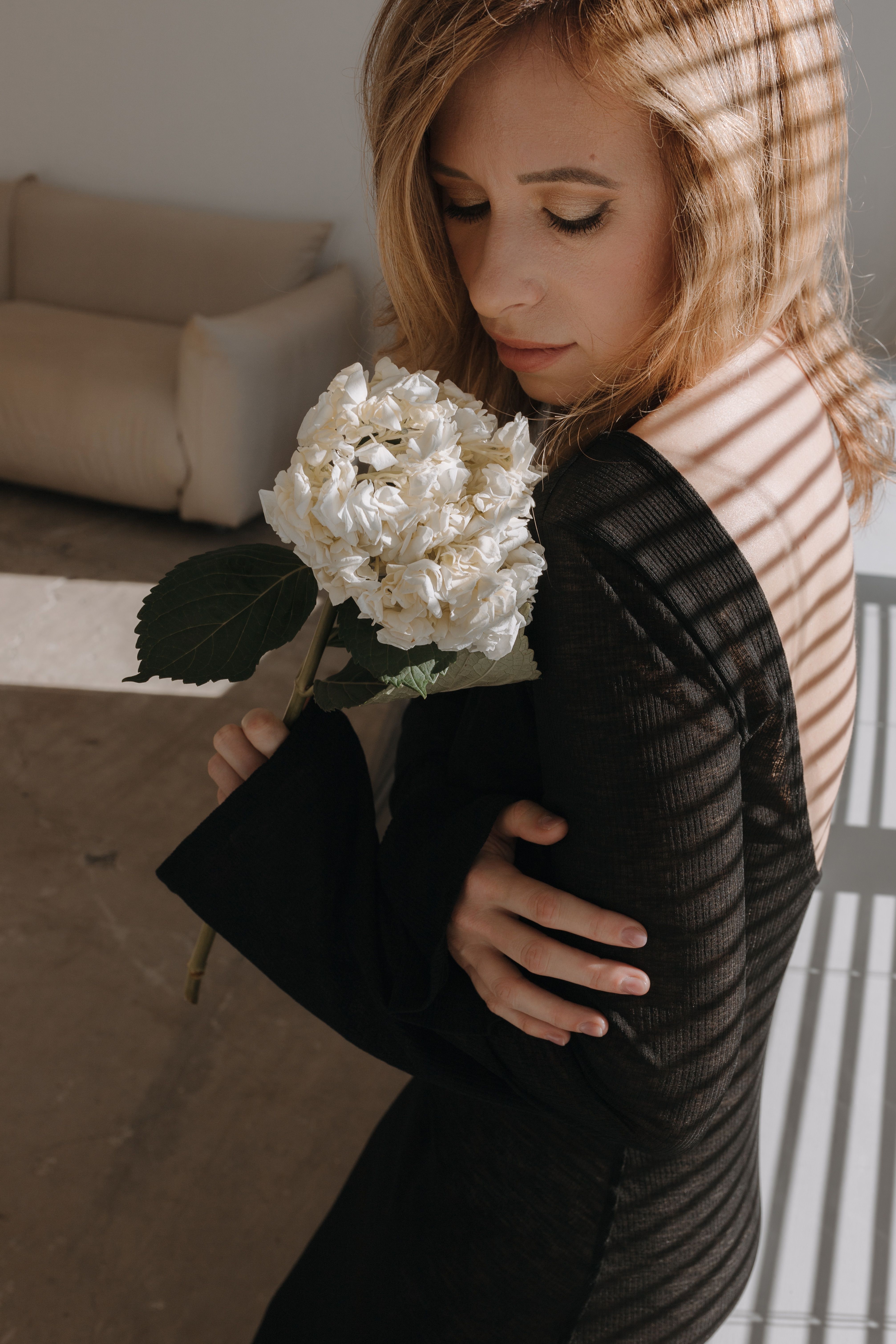 Photo of a Young Woman in a Black Dress Holding White Flowers · Free ...