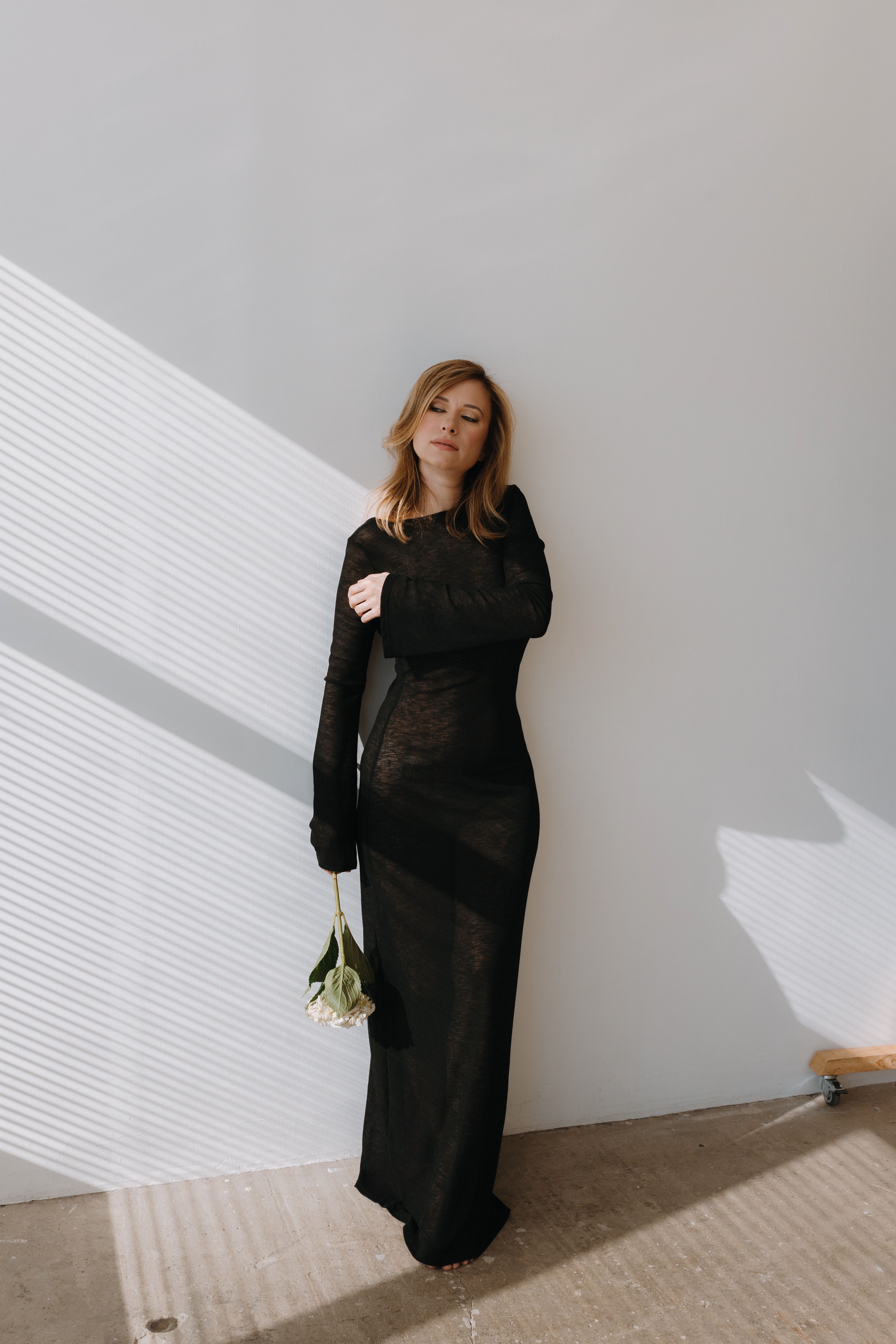 Photo of a Young Woman in a Black Dress Holding Flowers · Free Stock Photo