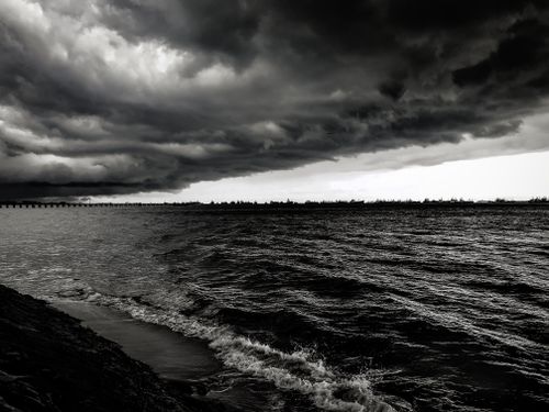 Free Monochrome seascape showcasing dramatic clouds over calm waters, perfect mood setting. Stock Photo