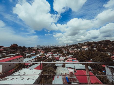 Expansive view of urban residential rooftops leading to a distant modern skyline.