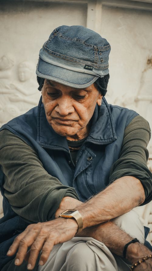 Free Portrait of an elderly man wearing a denim cap, vest, and wristwatch in Ahmedabad, India. Stock Photo