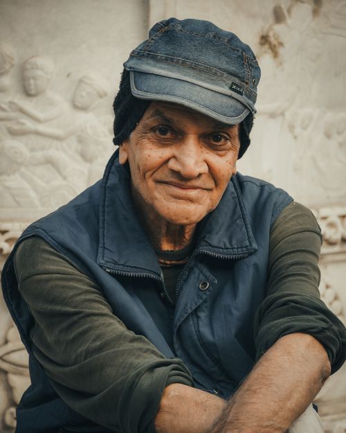Free A heartfelt portrait of an elderly man wearing a cap, sitting outdoors in Ahmedabad. Stock Photo