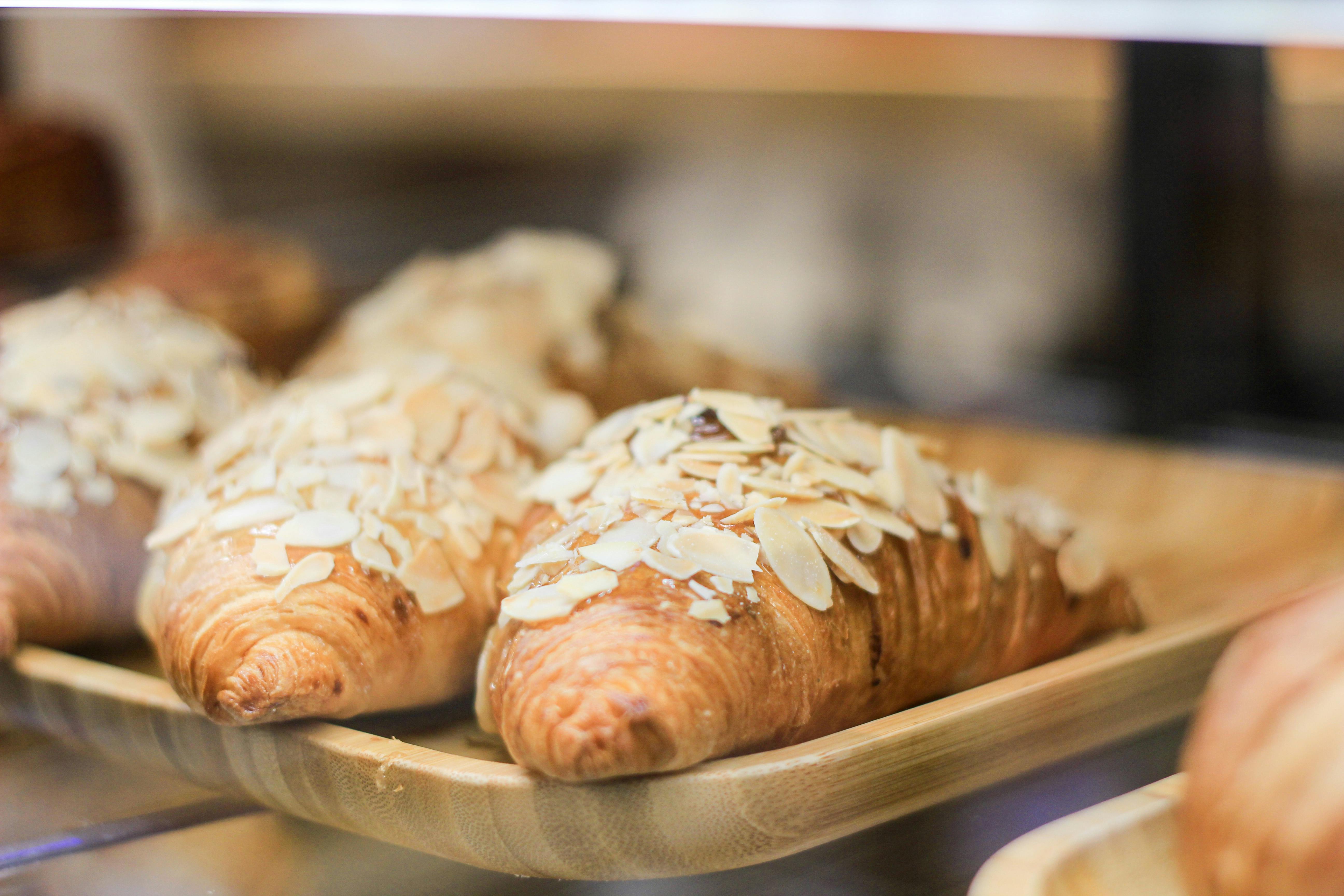 Close-up of delicious almond croissants on tray in a café bakery.