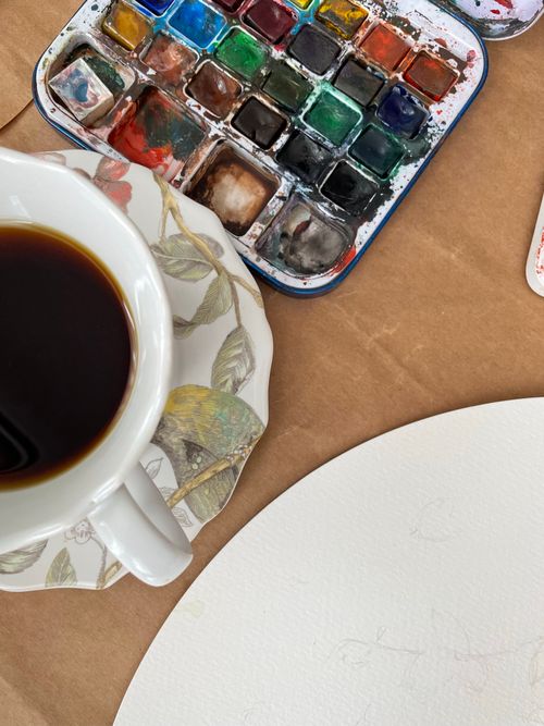 Free Top view of a creative art setup with watercolor paints and a coffee cup. Stock Photo