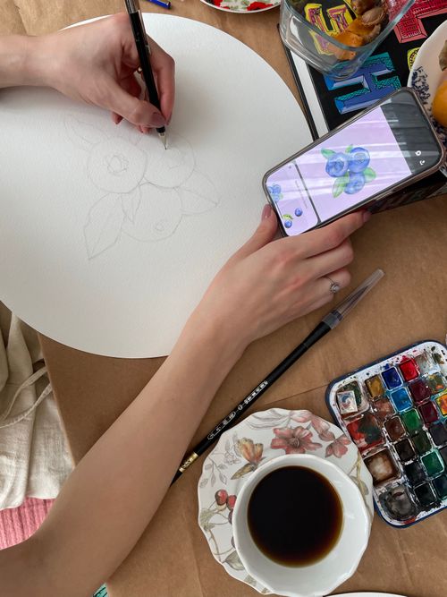 Free A creative workspace with sketching in progress, watercolors, and coffee. Stock Photo