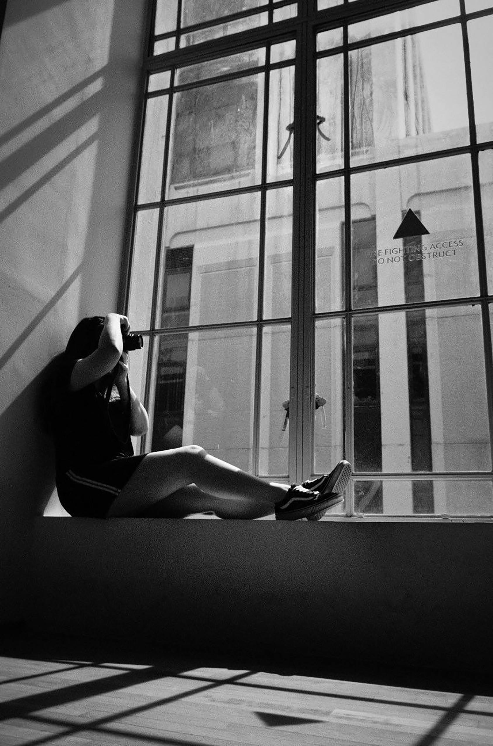 一个女人在大窗户旁拍下黑白剪影照