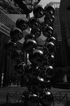 黑白照片中醒目的现代雕塑映照出市中心的城市景观