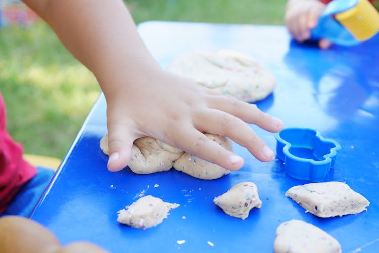 Photo Of Child's Hand Playing Clay