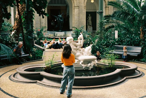 A woman is standing in front of a fountain