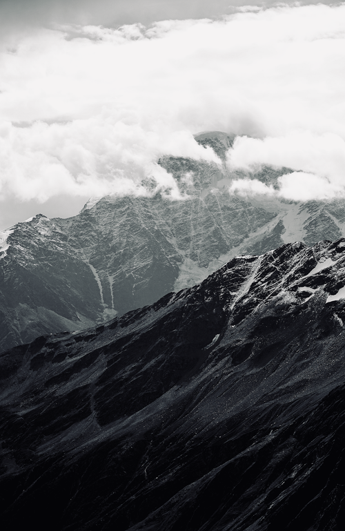 Free Dramatic view of snowcapped mountains and clouds contrasting in a black and white landscape. Stock Photo