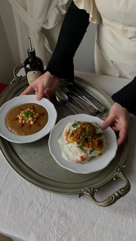 Close-up of a chef presenting homemade dishes on a tray, showcasing food artistry.