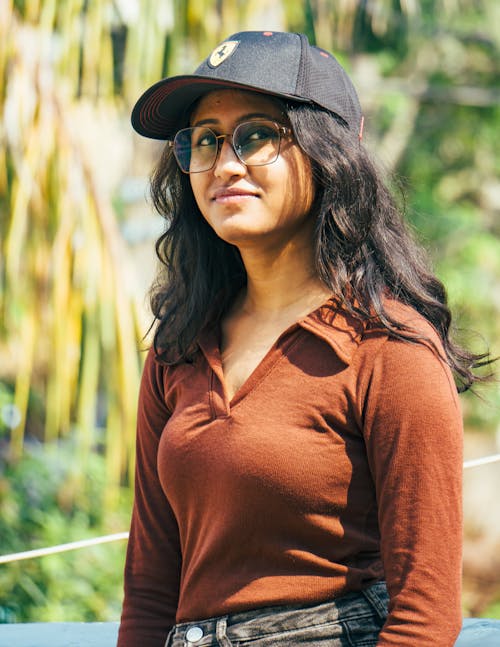 A woman in a brown shirt and black hat