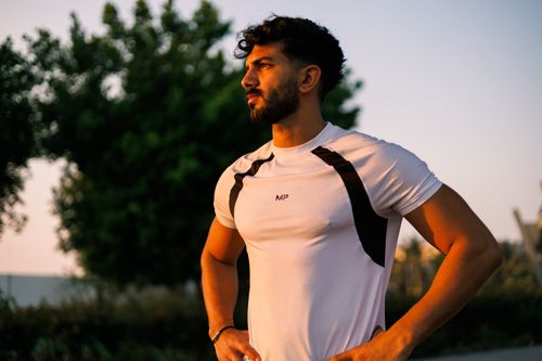 Free Athletic man in a white shirt stands confidently during sunrise in Jeddah, Saudi Arabia. Stock Photo