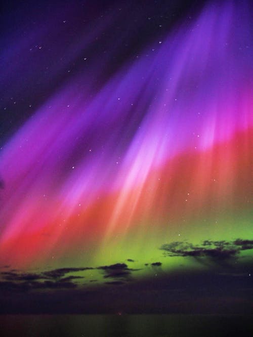 The aurora bore is seen in the sky above the ocean